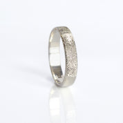 A sterling silver engraved fingerprint ring on its side. Custom fingerprint ring, thin handwriting band, sterling silver ring, gold engraved band, rose gold jewelry, unique names and dates, location coordinates, personal message, photo engraving option, versatile gift for him or her, US sizes 4-13, elegant design