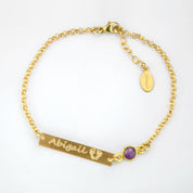 Single gold filled adjustable bar bracelet with name and footprints engraved with a purple amethyst birthstone. 