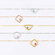 Eden bracelet open geometric series from top to bottom, sterling silver triangle with aqua chalcedony birthstone march birthstone. rose gold plated square with peridot birthstone august birthstone, gold plated triangle with iolite birthstone september birthstone, sterling silver circle charm with pink chalcedony birthstone october birthstone, gold plated square charm with ruby birthstone july birthstone on white background