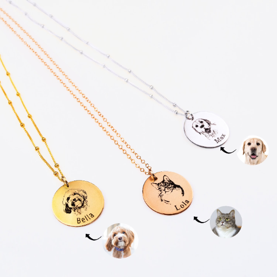 Three pet engraved disk necklaces are pictured. The first necklace is a satellite gold filled chain with modern thin font engraved name, middle rose gold cable chain necklace with cat and name engraved in classic font and a sterling silver satellite chain with a dog and name engraved in typewriter font. 