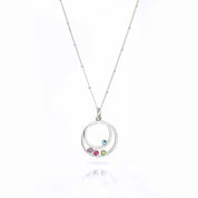 Single sterling silver satellite chain with two orbit pendants with blue topaz and purple amethyst, ruby and peridot birthstones on white background.
