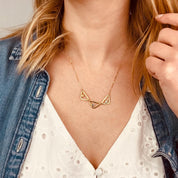 Model in white top is wearing a gold filled open triangle geometric necklace with citrine, purple amethyst and aqua chalcedony birthstones