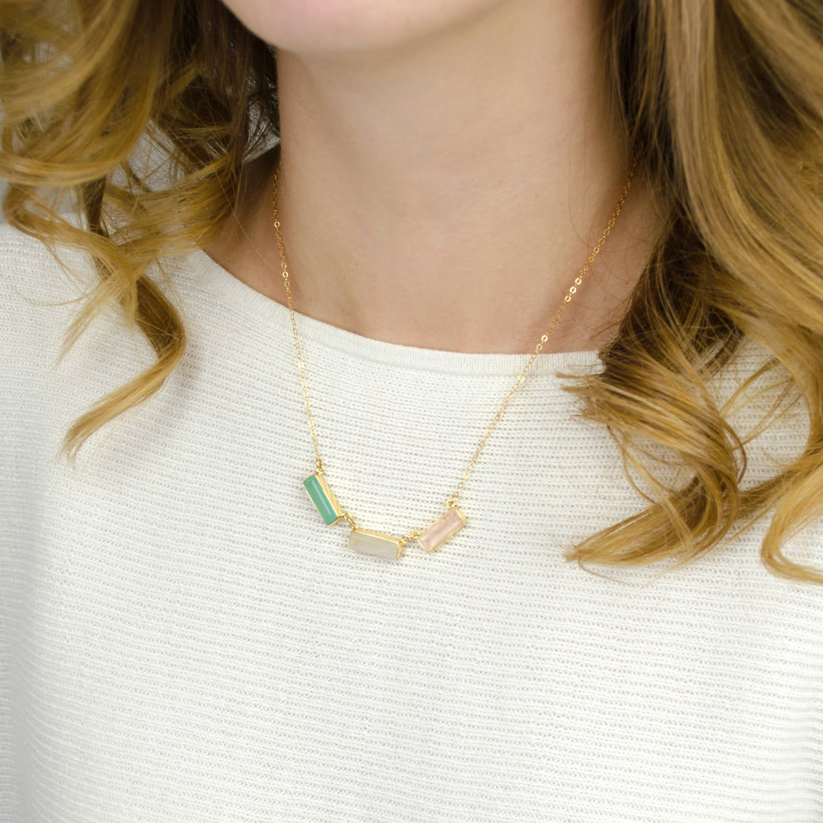 Model is wearing a gold filled adira necklace with green onyx, moonstone and pink quartz stones. 