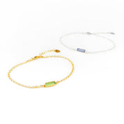 Two alternating gold filled and sterling silver chain adira bar bracelets featuring peridot and labradorite birthstones on white background