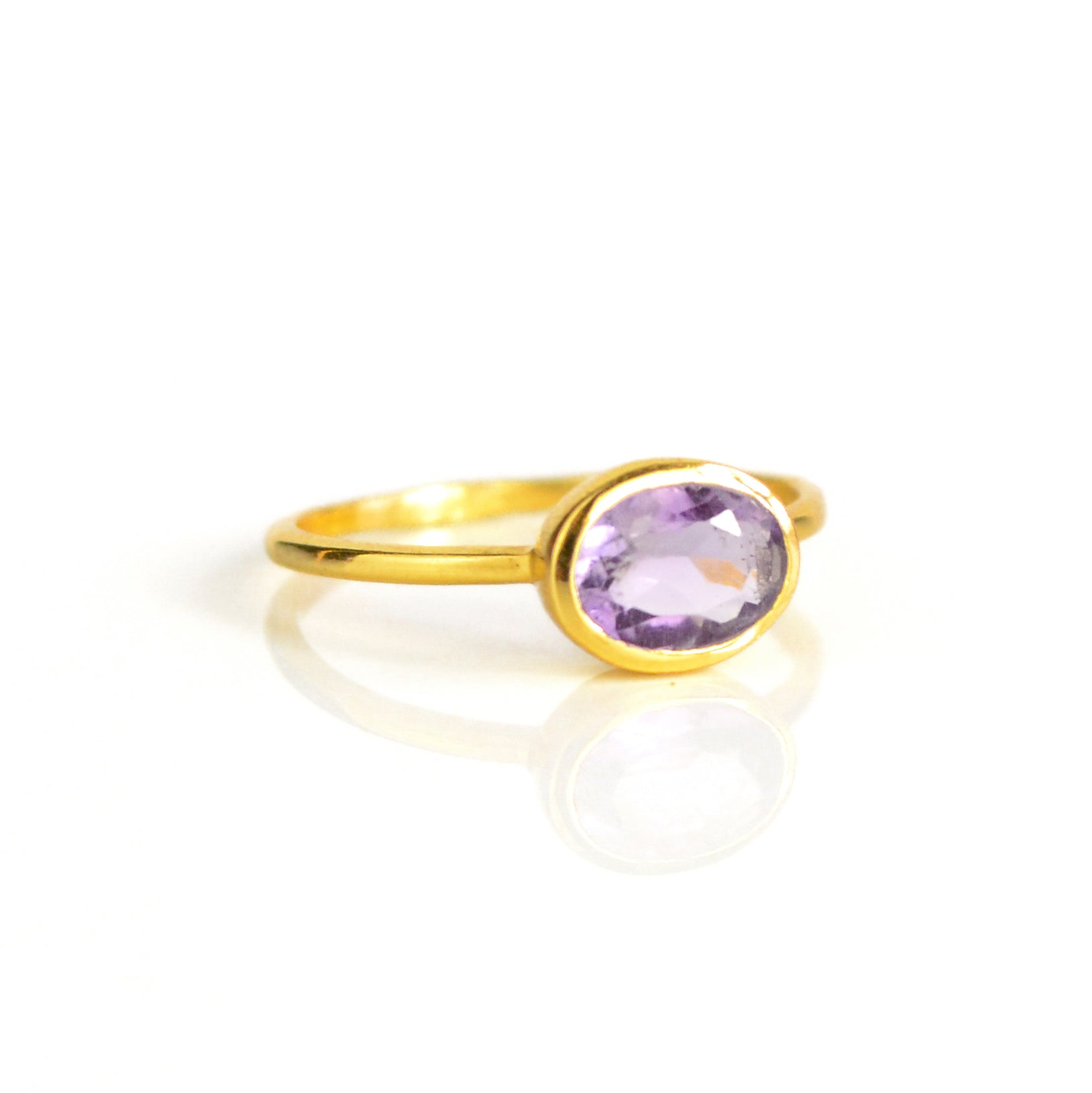 a gold purple amethyst ring shown on white background. stackable! Stacking rings, bezel set, small oval, tiny oval, dainty oval, birthstone rings, sterling silver stamp, birthstone ring, birthstone jewelry, purple gemstone, purple birthstone, february birthstone, february gemstone