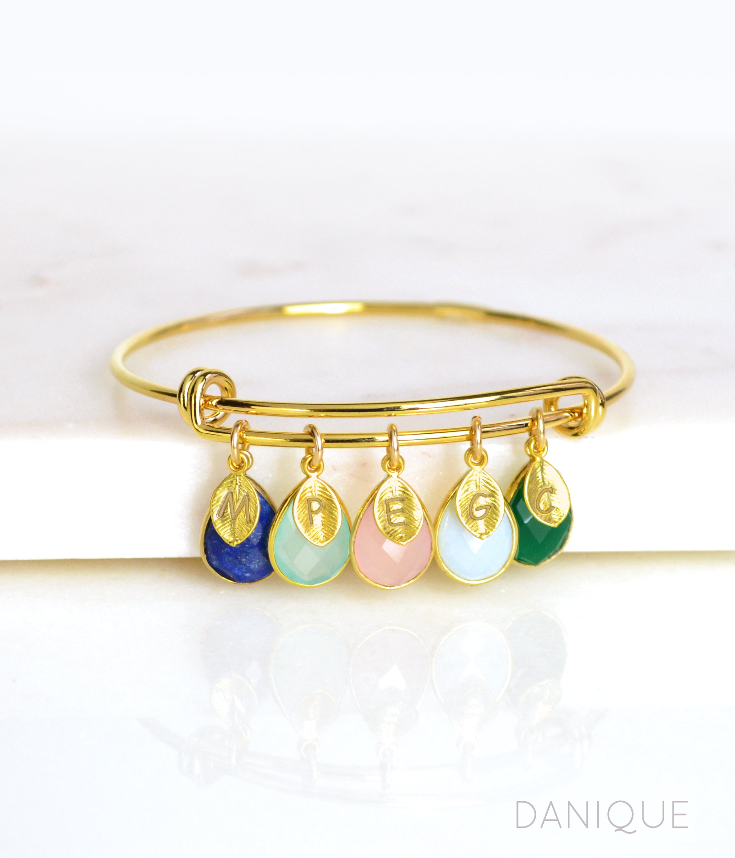 Single gold bangle bracelet with stamped leaf charms and lapis, aqua chalcedony, piny chalcedony, opalite and green onyx birthstones.