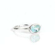 a sterling silver blue topaz ring shown on white background. stackable! Stacking rings, bezel set, small oval, tiny oval, dainty oval, birthstone rings, sterling silver stamp, birthstone ring, birthstone jewelry, blue gemstone, blue birthstone, december birthstone, december gemstone