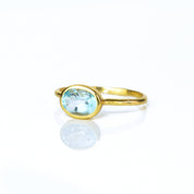 a gold blue topaz ring shown on white background. stackable! Stacking rings, bezel set, small oval, tiny oval, dainty oval, birthstone rings, sterling silver stamp, birthstone ring, birthstone jewelry, blue gemstone, blue birthstone, december birthstone, december gemstone