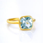 blue topaz gold plated cushion square stacking ring on white background. december birthday, december gemstone