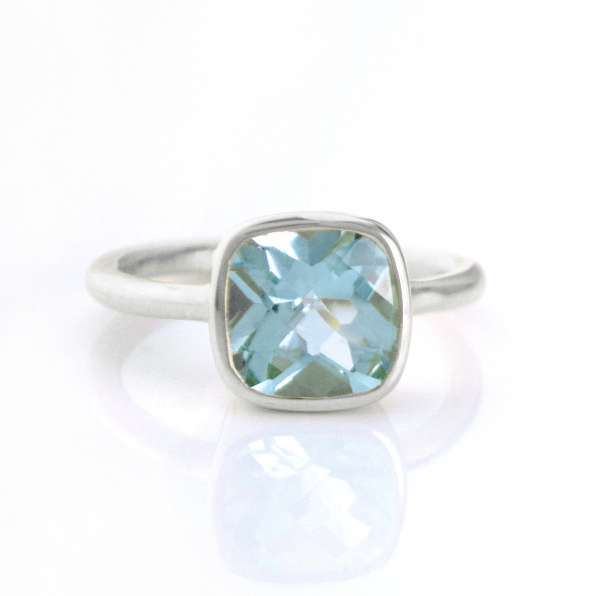 blue topaz in sterling silver cushion square stacking ring on white background. december birthday, december gemstone