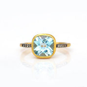 Gold plated blue topaz with white topaz pave setting ring on white background. December gemstone, december birthstone, december birthday. Bezel setting on white background