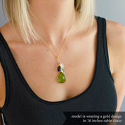 Model is wearing a single gold filled cable style cascade chain with large mother's peridot birthstone and three kid's stones including moonstone, kyanite and blue topaz