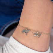 Model is wearing a sterling silver charm anklet with a cat and dog charms to memorialize their pets. 