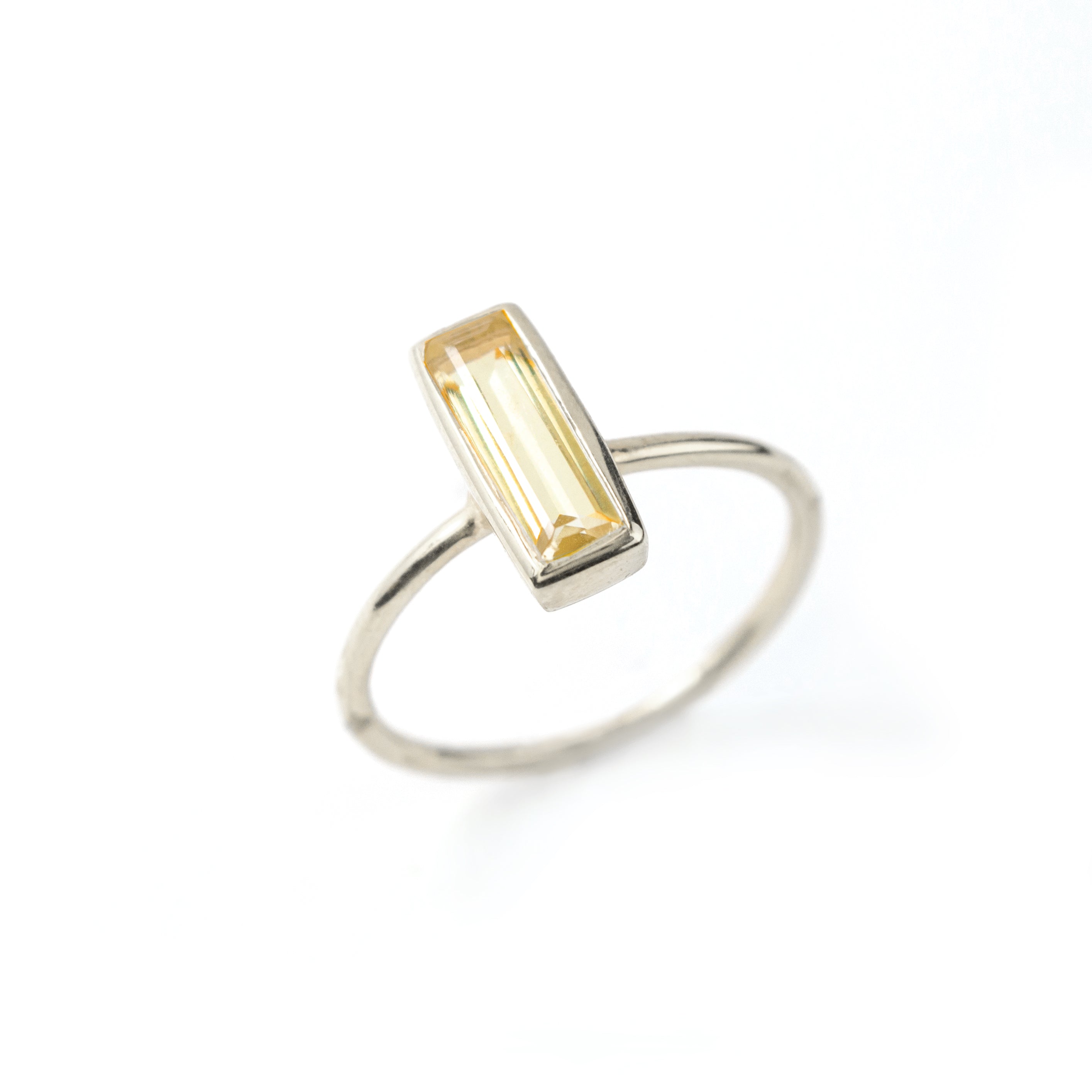 Sterling Silver tiny gemstone adira bar ring with citrine birthstone on white background. 