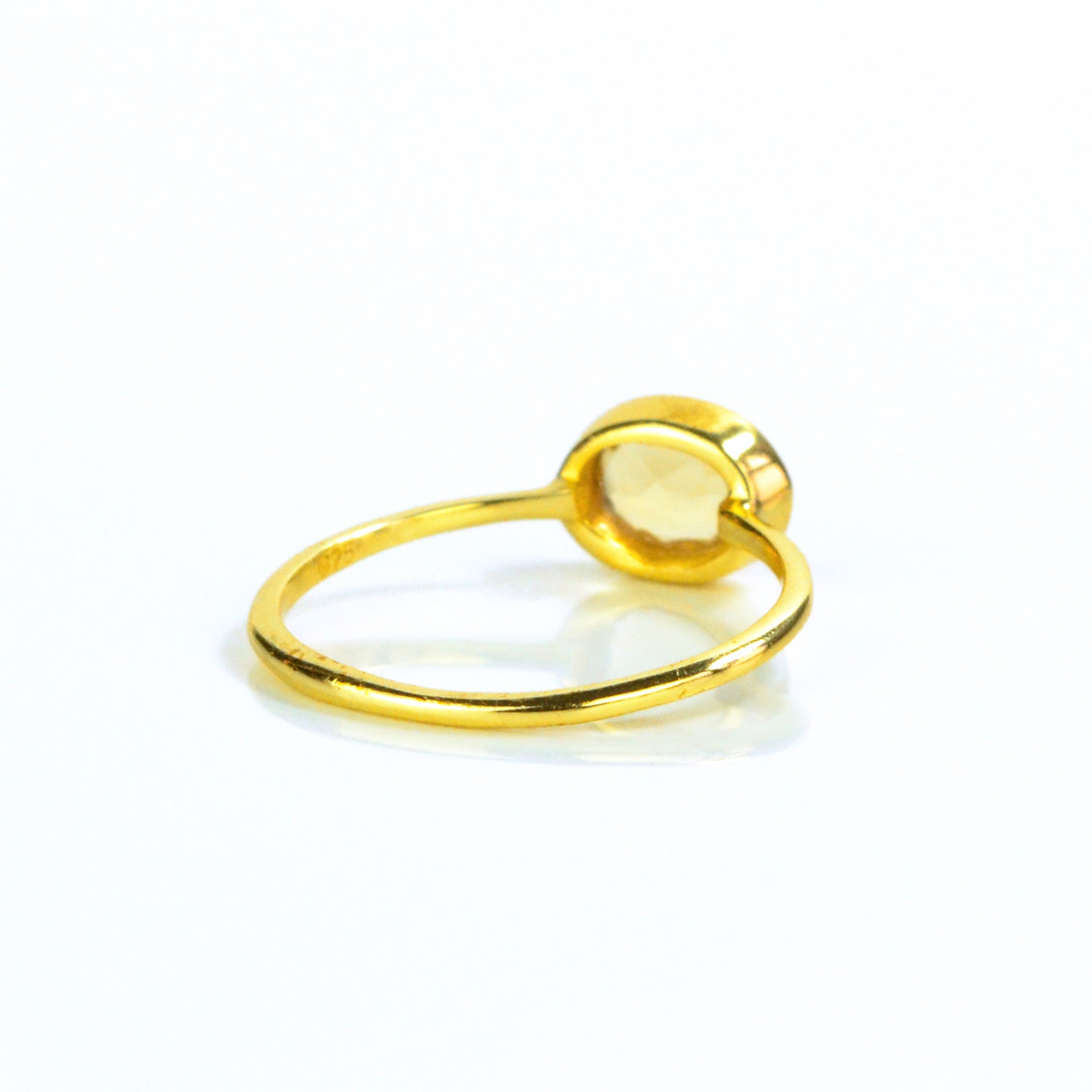 Small oval citrine birthstone november gemstone ring facing away, back view. Bezel set tiny ring. 