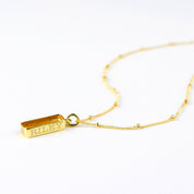 Single gold filled satellite chain vertical citrine november birthstone adira bar necklace with secret message engraved in classic font on white background