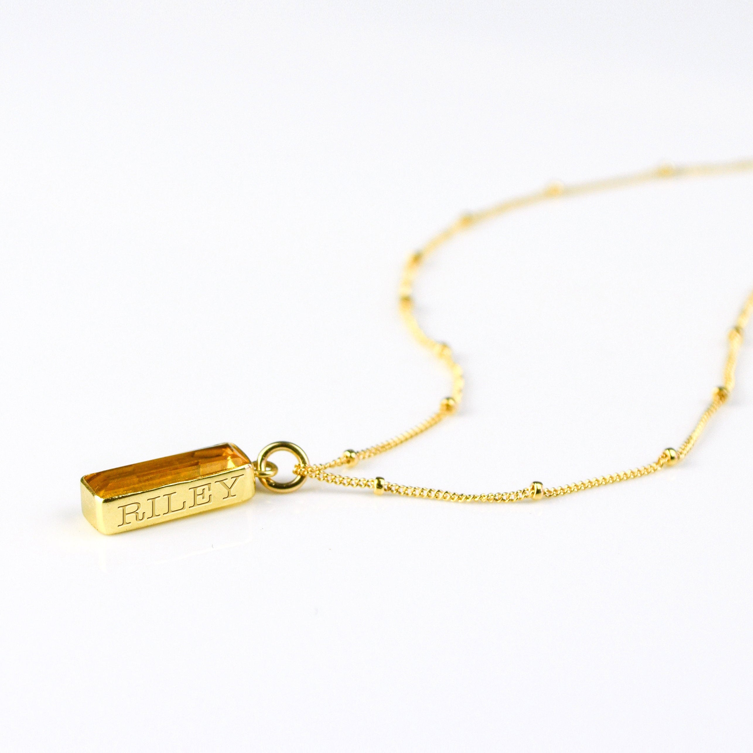 Single gold filled satellite chain vertical citrine november birthstone adira bar necklace with secret message engraved in classic font on white background