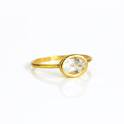 a gold clear quartz ring shown on white background. stackable. Stacking rings, bezel set, small oval, dainty oval, birthstone rings, sterling silver stamp, birthstone ring, birthstone jewelry, clear gemstone, clear quartz birthstone, april birthstone, april gemstone,  stack set, stacking rings, christmas gift, birthstone ring, mother's day gift for her, gift for mom, gift for fiance, gift for girlfriend, wedding jewelry, bridesmaid jewelry, anniversary jewelry, anniversary gift, birthday gift