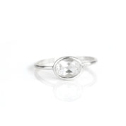 a sterling silver clear quartz ring shown on white background. stackable. Stacking rings, bezel set, small oval, dainty oval, birthstone rings, sterling silver stamp, birthstone ring, birthstone jewelry, clear gemstone, clear quartz birthstone, april birthstone, april gemstone,  stack set, stacking rings, christmas gift, birthstone ring, mother's day gift for her, gift for mom, gift for fiance, gift for girlfriend, wedding jewelry, bridesmaid jewelry, anniversary jewelry, anniversary gift, birthday gift