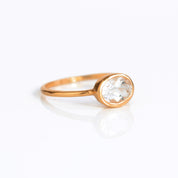 a rose gold clear quartz ring shown on white background. stackable! Stacking rings, bezel set, small oval, tiny oval, dainty oval, birthstone rings, sterling silver stamp, birthstone ring, birthstone jewelry, clear gemstone, clear quartz birthstone, april birthstone, april gemstone