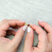 Model is holding a custom mom and children's birthstone ring with ruby representing mom and citrine and peridot for the kids birthstones. 