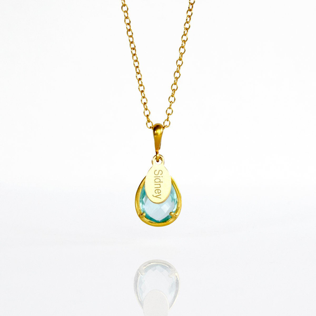 December Sky Blue Quartz Gold Necklace with with personalized engraved name tag in gold plating on white background. Teardrop birthstone december gemstone december birthday light blue