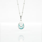 Sterling silver satellite December Sky Blue Quartz Necklace with personalized engraved script initial tag on white background. Teardrop birthstone december gemstone december birthday light blue