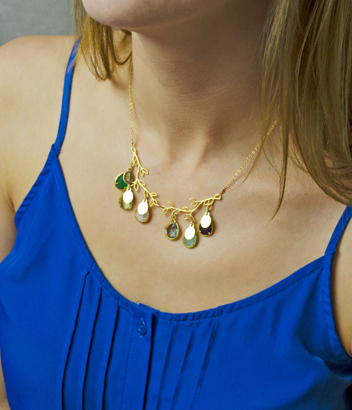 Model in blue top is wearing our branch necklace with prong set birthstone and engraved oval name tags. 