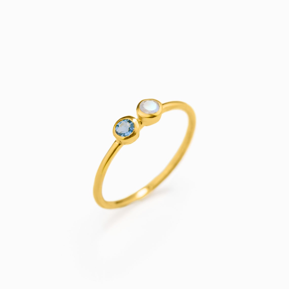 Single gold filled dual birthstone ring with kyanite and moonstone gemstones on white background.