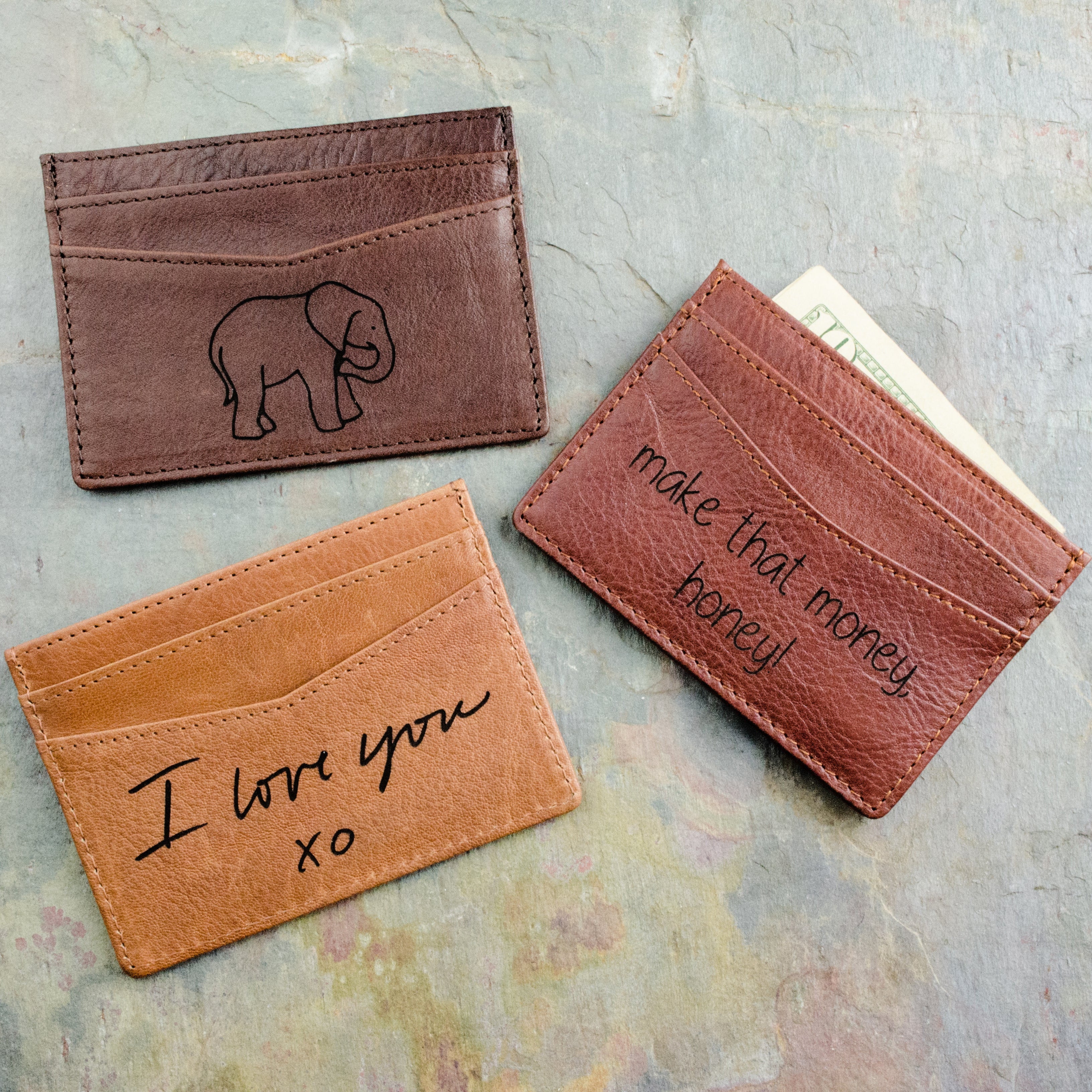 actual handwriting or drawing laser Custom engraved slim leather card holders featuring unique artwork designs including elephant engraving and “I love you xo” message. These personalized wallets make heartfelt gifts for boyfriends, husbands, or dads, and are ideal for anniversaries, Valentine’s Day, Christmas, or Father’s Day. Handcrafted from full-grain leather with multiple card slots, this minimalist card holder is stylish, practical, and deeply meaningful.