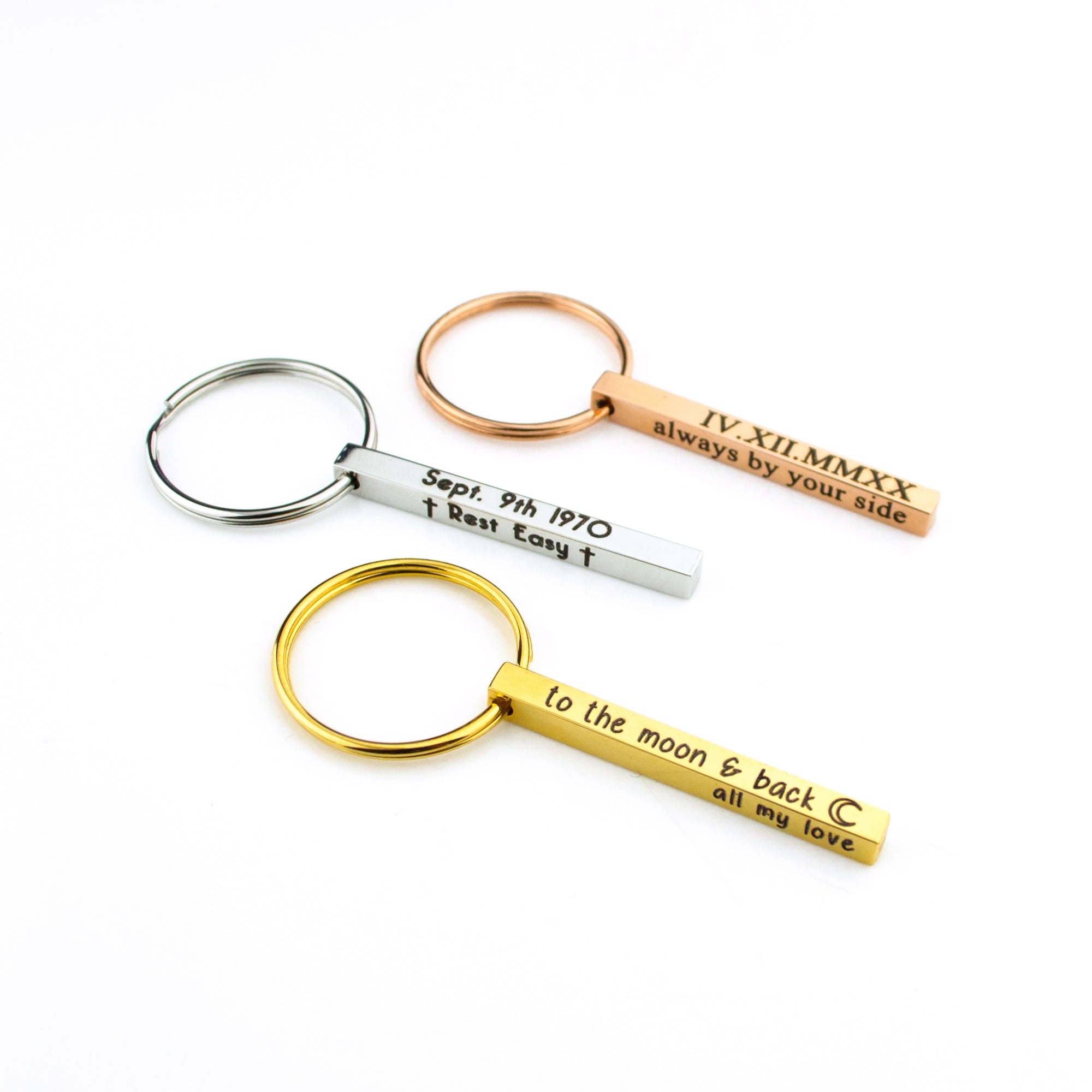 Set of mini engraved bar keychains in silver, gold, and rose gold arranged together to compare tones and engraving contrast. The mini bar keychain size (40×4 mm) balances lightweight comfort with readable text on up to four sides. A versatile engraved keychain choice for names, initials, dates, and roman numeral keychain designs—perfect for anniversaries, graduations, and travel keepsakes.