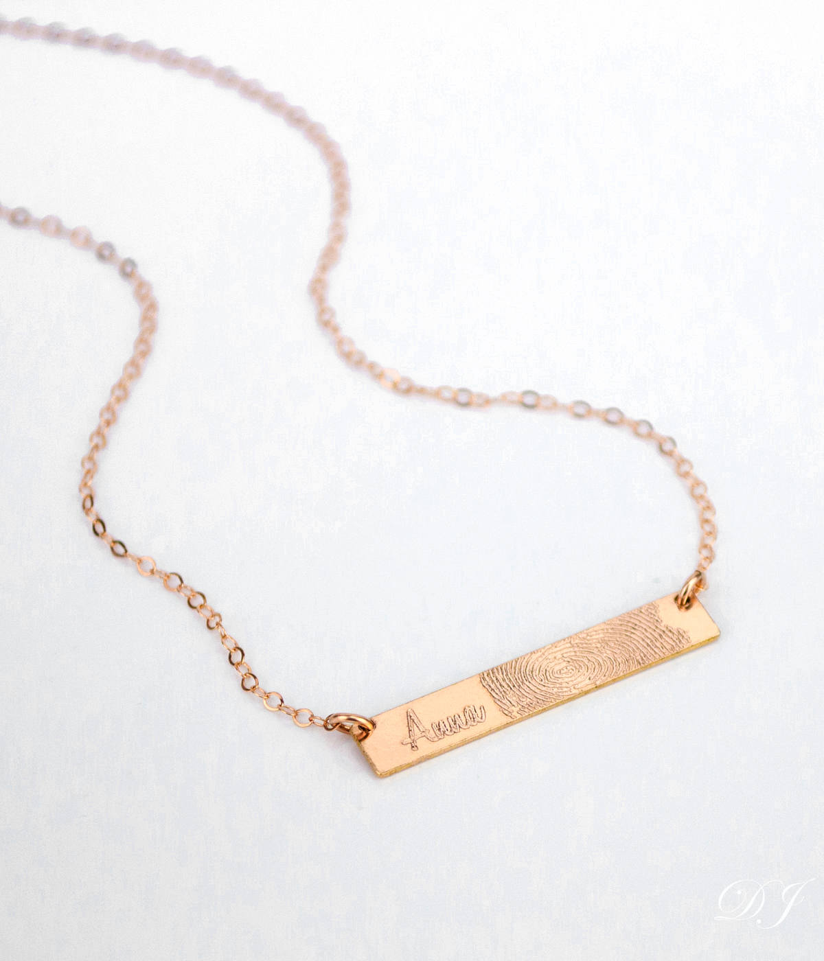 A rose gold necklace with a name and a fingerprint against a white background. Custom engraved bar jewelry Minimalist initial bar necklace Engraved vertical bar necklace Custom date bar necklace Personalized minimalist jewelry Engraved bar charm necklace Custom nameplate bar necklace Minimalist custom pendant