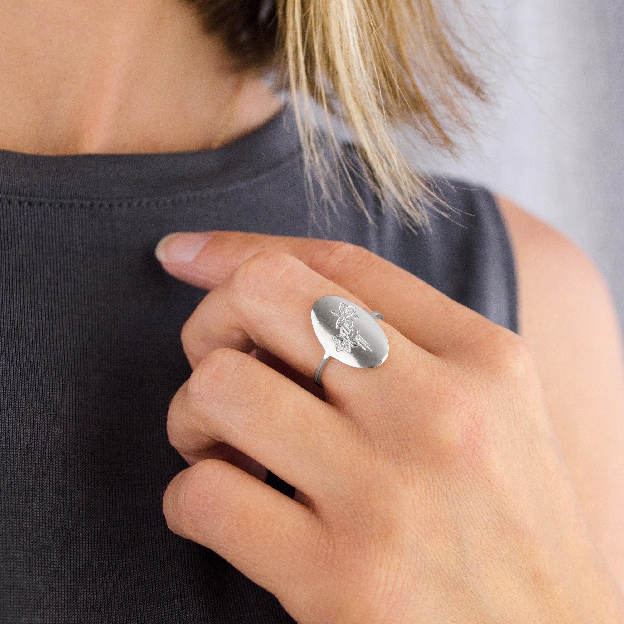 Model wears sterling silver flower engraved ring