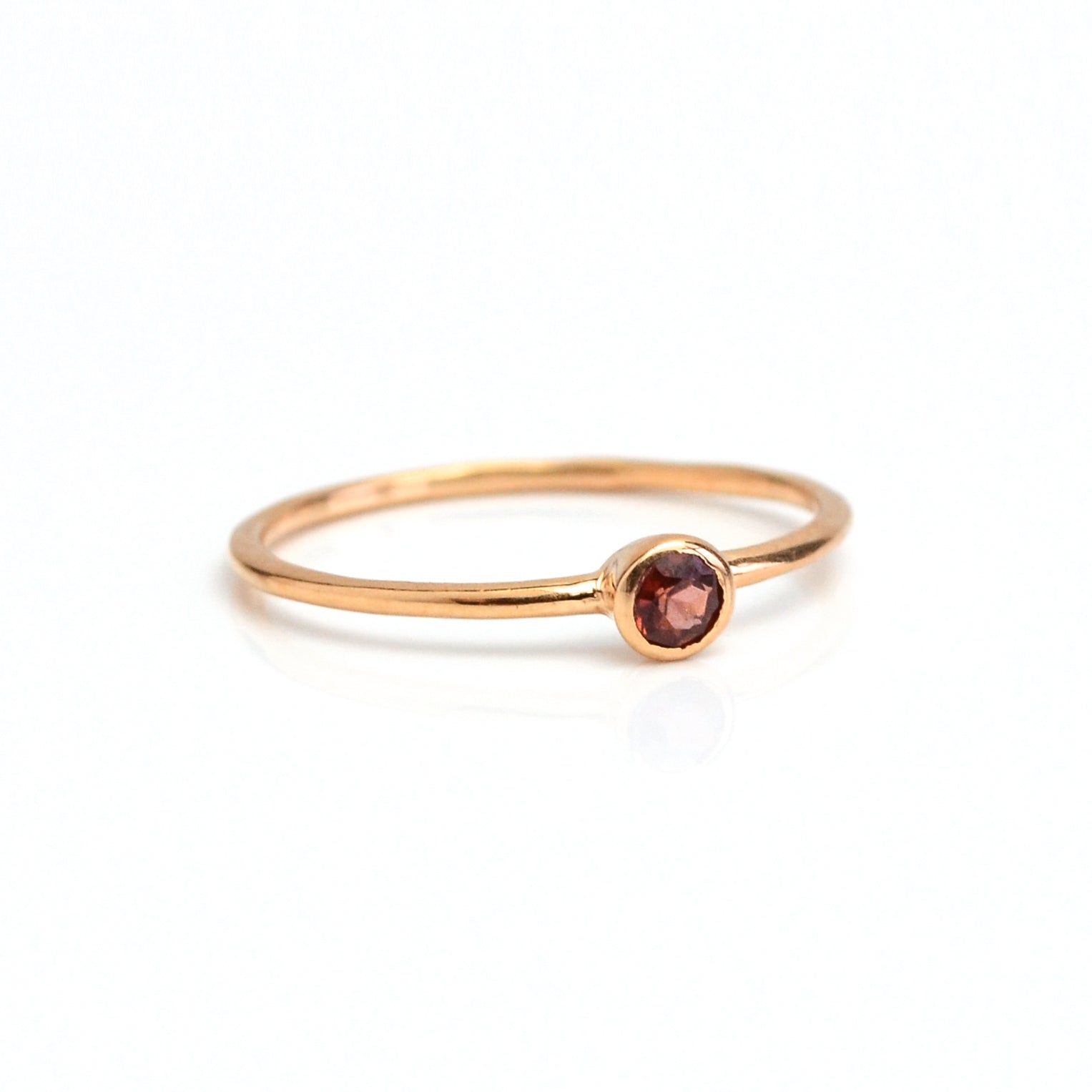 Single rose gold plated dainty 3mm garnet gemstone ring. January birthstone. On white background. 925 sterling silver, birthstone ring, stacking ring, stackable, birthstone jewelry, facet gemstone