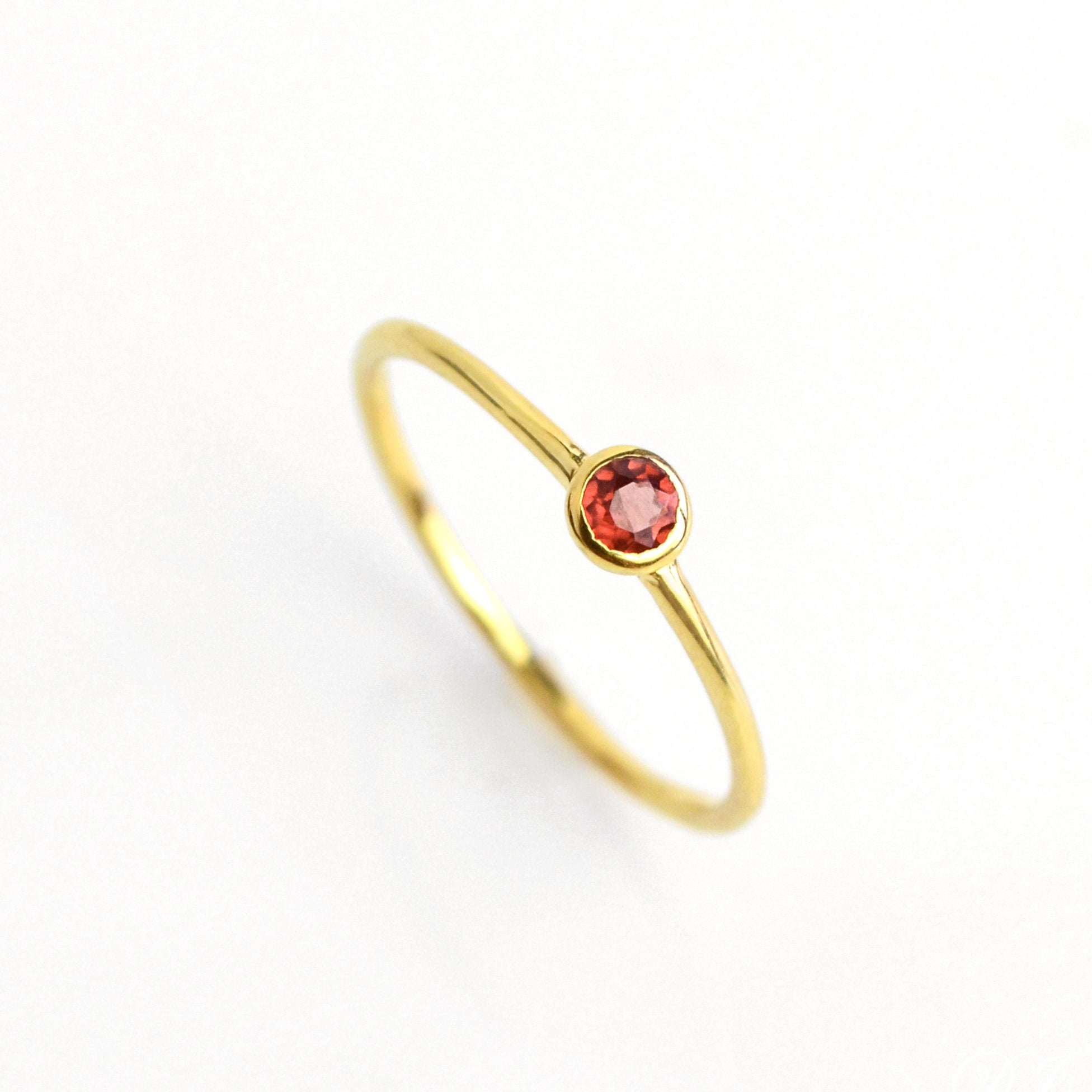 Single gold plated dainty 3mm garnet gemstone ring. January birthstone. On white background. 925 sterling silver, birthstone ring, stacking ring, stackable, birthstone jewelry, facet gemstone
