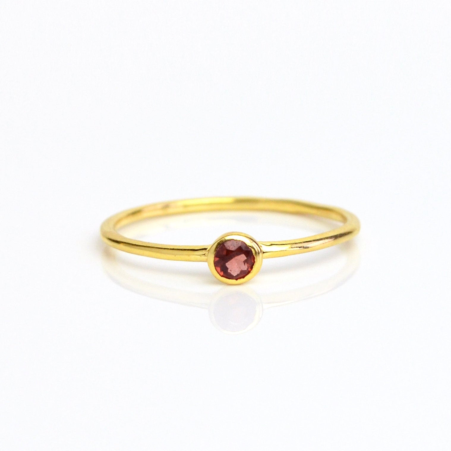 Single gold plated dainty 3mm garnet gemstone ring. January birthstone. On white background. 925 sterling silver, birthstone ring, stacking ring, stackable, birthstone jewelry, facet gemstone