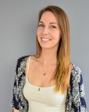 Model in white top is layering a disk necklace with the vertical gold filled peridot bar necklace