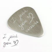 Single guitar pick with I pick you design, heart and date engraved on white background.