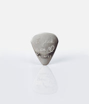 Single guitar pick with I pick you design, heart and date engraved on white background.