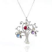 Single silver swirly tree necklace with hand stamped leaf charms and kyanite, dyed ruby and purple amethyst birthstones. 