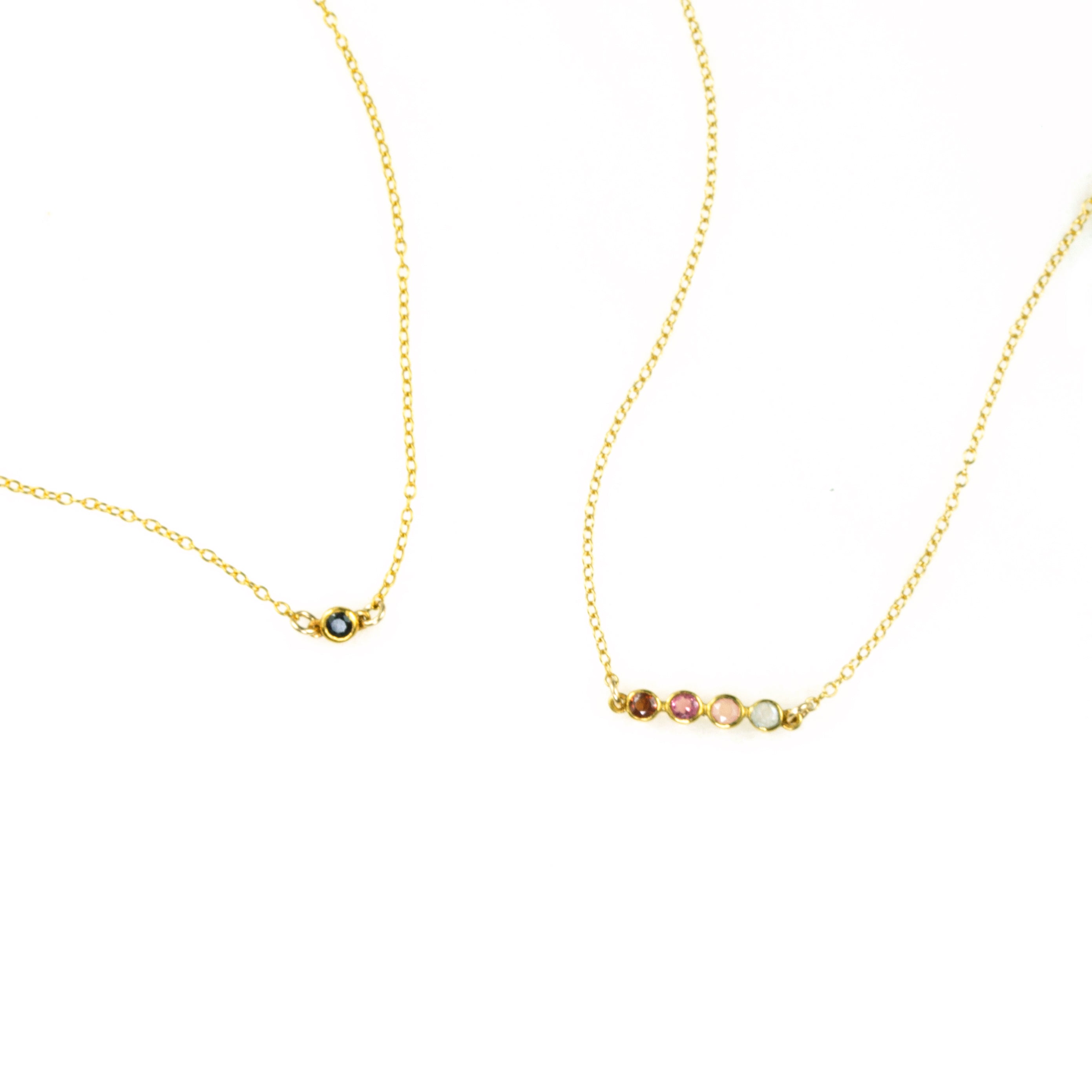 One gold filled black onyx birthstone connector necklace. One four stone dainty birthstone necklace featuring garnet, ruby, pink chalcedony and aqua chalcedony. 