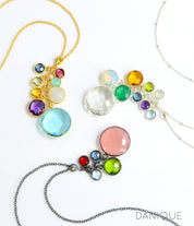 Gift for Grandma Family Necklace With Kids and3 cascade birthstone necklaces in gold, silver and oxidized silver lay in a swirling pattern on a white background. Grandkids Birthstones Gold or Silver, October birthstone necklace for grandma, December birthstone necklace for grandma, April birthstone necklace for grandma, personalized birthstone jewelry for grandmother
