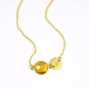 Single gold filled citrine birthstone november birthstone jewelry necklace with brushed initial disk on a white background.