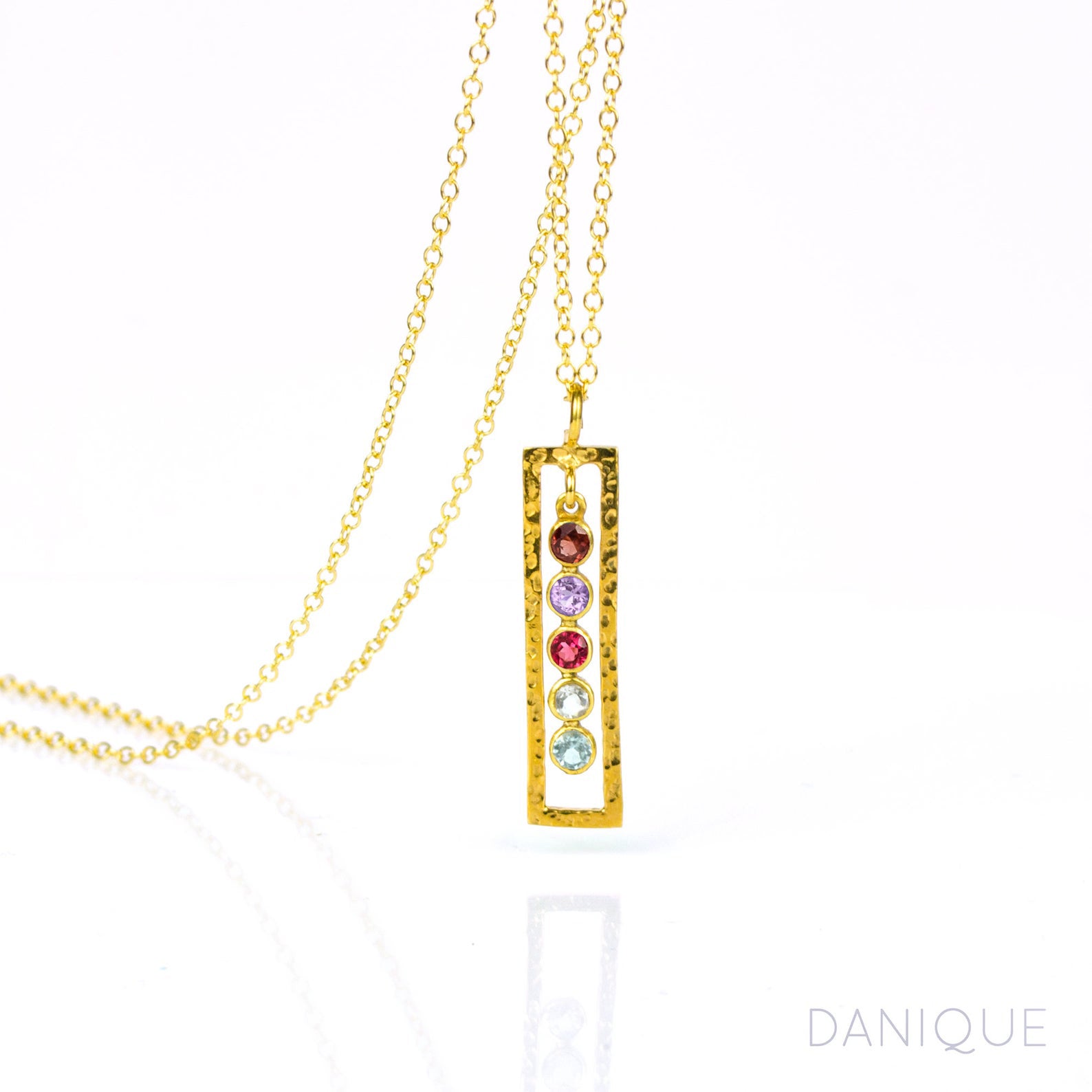 Single gold filled open frame necklace featuring 5 birthstones including garnet, purple amethyst, ruby, green amethyst and blue topaz. 