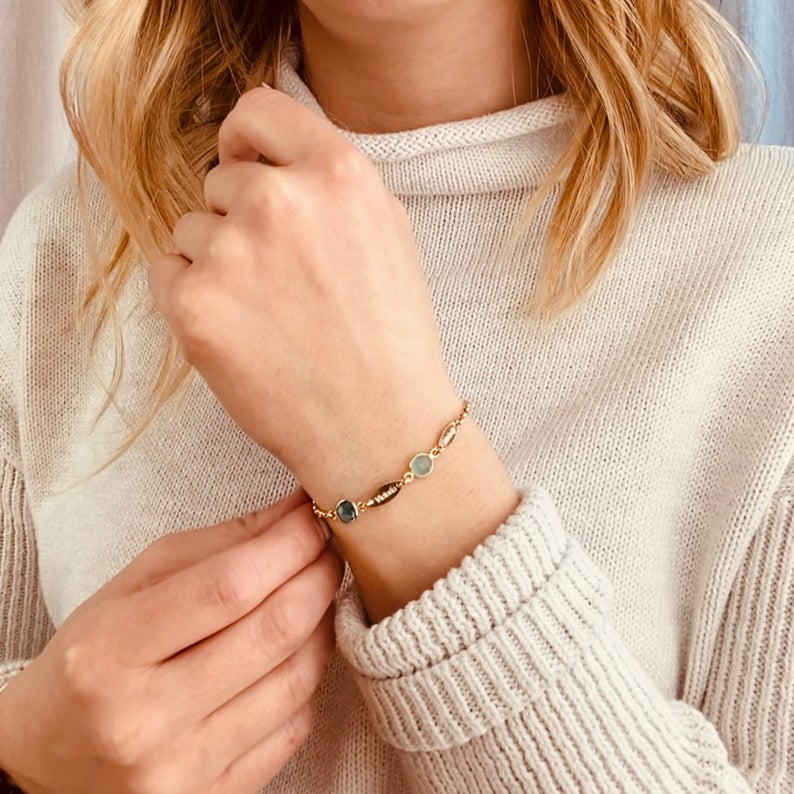 Model is wearing our gold filled 6mm birthstone bracelet with kyanite and aqua chalcedony stones and two marquis engraved name tags. 