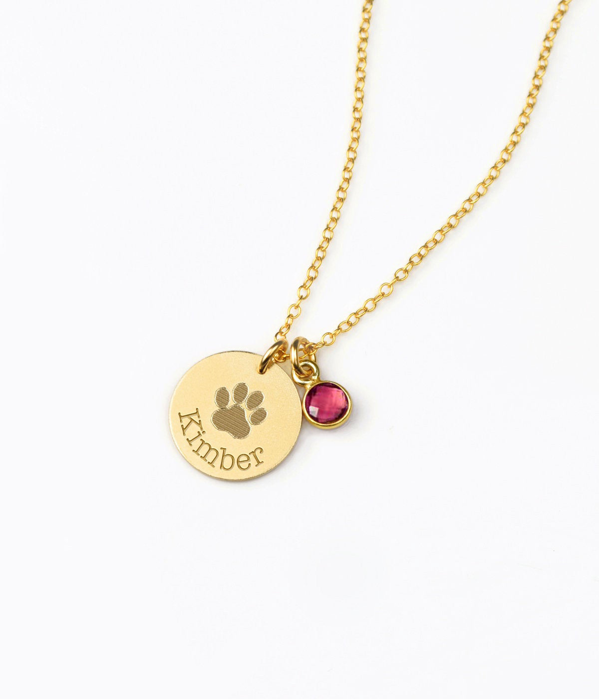 A gold engraved paw print necklace with a ruby July birthstone.  Paw print disc necklace, dainty pet jewelry, custom birthstone necklace, sterling silver pet necklace, gold-filled disc pendant, rose gold-filled pet necklace, personalized pet lover gift, custom engraved jewelry, pet keepsake necklace, unique pet memorial necklace
