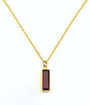 Single gold filled cable chain vertical garnet quartz january birthstone adira bar necklace on white background