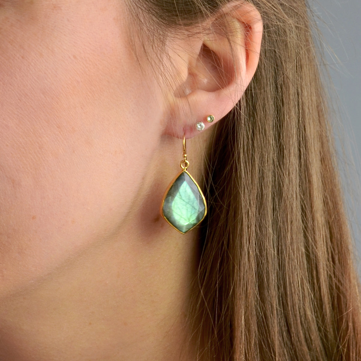 Gold labradorite earrings pear shaped gemstone drop earrings on a model