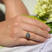 Model is wearing the labradorite with white topaz pave square cushion bezel set ring in gold plating. Sterling silver ring. 