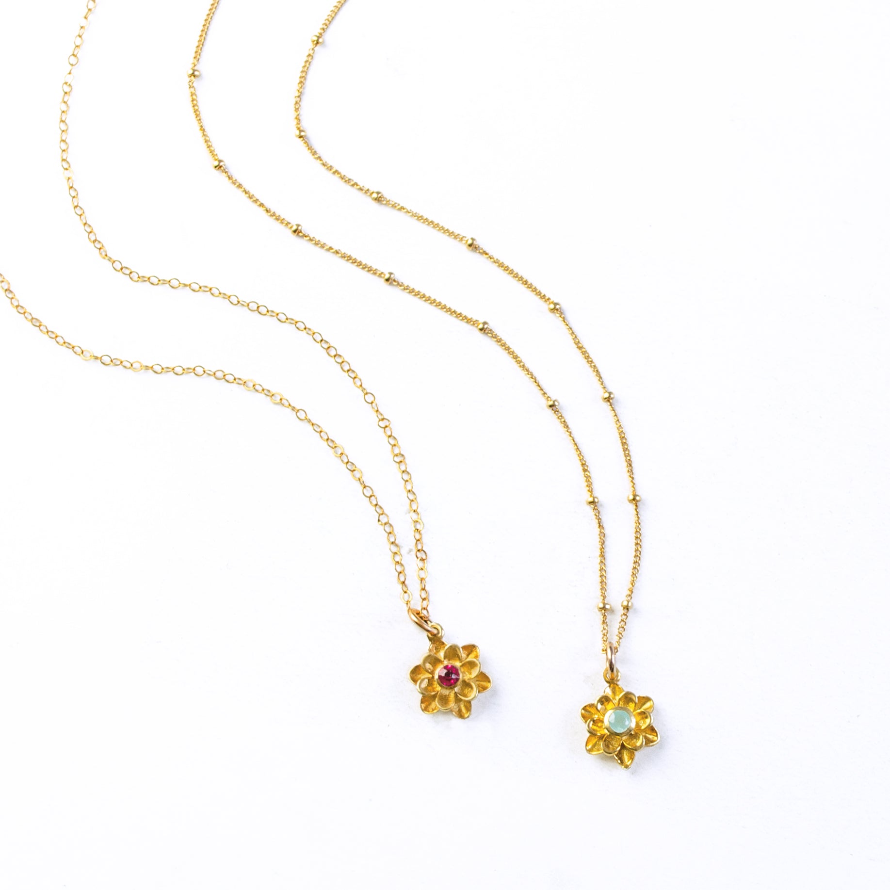 Two large blossom floral bloom necklaces first with cable chain and ruby birthstone and second with satellite chain and aqua chalcedony birthstone. 